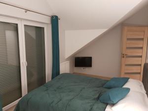 希维拉杜夫-兹德鲁伊Vera Apartment Świeradów-Zdrój Zakopiańska 22 C m10的一间卧室配有一张带绿色床单的床和一台电视。