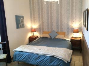 CendrieuxLa Banne Nord的一间卧室配有一张带两盏灯和吊灯的床。