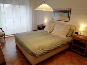 罗马Casa Pinturicchio的一间卧室配有一张大床、两张桌子和两盏灯。