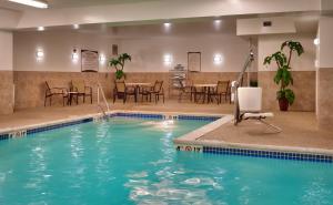 奥马哈奥马哈第80道奇驻桥套房酒店的酒店客房的游泳池配有桌椅