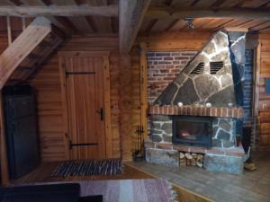 奥泰佩Vana-Laane Puhkemaja的小木屋内带石头壁炉的房间