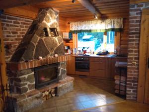 奥泰佩Vana-Laane Puhkemaja的小屋内的厨房设有石制壁炉