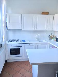 托尔博莱Appartamento Ellen的白色的厨房配有白色橱柜和炉灶。