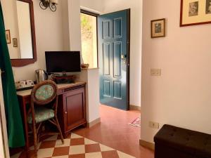 帕尔盖利亚维里诺爱莲住宿加早餐旅馆的一间设有蓝色门的房间和一张带电视的书桌