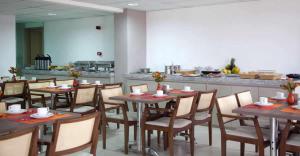 费拉迪圣安娜艾特莫斯费拉酒店的一间带木桌椅的餐厅和一间厨房