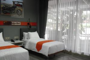 展玉Sturgis Boutique Hotel Cipanas的酒店客房设有两张床和窗户。