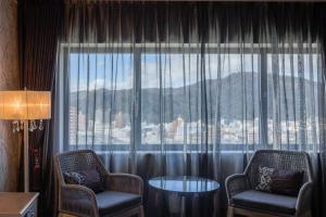 德岛新都酒店的客房设有两把椅子和大窗户