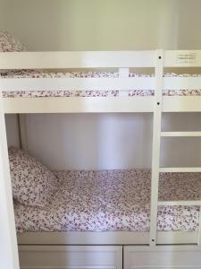 乌瑞基尼appartement domaine de Bordaberry Urrugne的一间卧室配有两张双层床,铺着粉红色的鲜花
