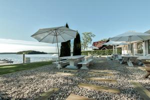 多洛托沃加勒里69旅馆的一组野餐桌和雨伞在水边