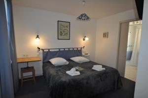 莱斯波特斯Le Concept Hotel的一间卧室配有一张床和一张桌子,上面配有毛巾