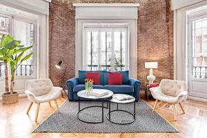 马德里Sagasta Suites Luxury Apartments的客厅配有蓝色的沙发和两把椅子