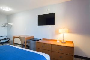 皮奥里亚Americas Best Value Inn East Peoria的酒店客房设有一张床、一张书桌和一台电视机。