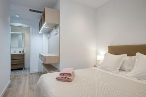 巴塞罗那LucasLand Apartments Barcelona的一间卧室配有一张床,床上铺有粉红色的毛巾