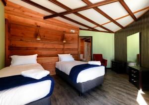 South BrunyTaylors Bay Cottage的木墙客房的两张床