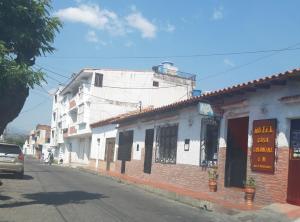 San Antonio del TáchiraHOTEL CASA COLONIAL的街道上,有建筑物和汽车,沿着街道行驶