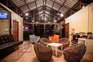 曼谷Tuscany Land Resort Donmuang的客厅配有椅子、桌子和沙发