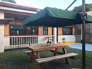 公主港Mayumi Lodge的大楼前带雨伞的野餐桌