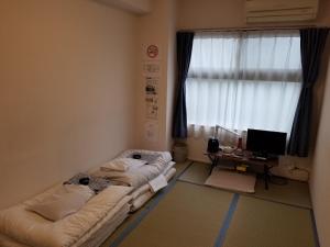 京都Ika Tsumesyo的带窗户的客房内的两张床