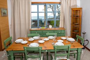 卡利诺岛Villa Popillon 1的一张带绿色椅子的木桌和窗户