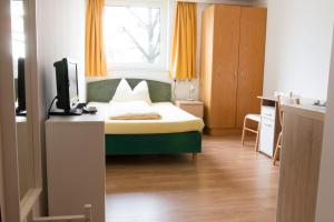 因斯布鲁克Wohnen in Innsbruck的一间卧室配有一张床和一张书桌及电视