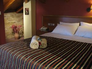 卢特拉伊帕蒂斯Hotel Prigipikon Suites and sofites的一间卧室配有带毛巾的床