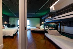 巴黎The ReMIX Hotel的一间卧室设有两张双层床,拥有绿色的墙壁
