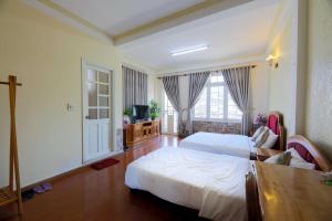 大叻The One Home Đà Lạt的卧室设有白色的床和大窗户