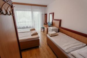 塞格德蒂萨体育酒店的小房间设有两张床和镜子