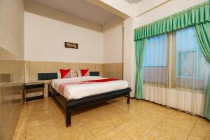 PatiSuper OYO 2855 Sartika Hotel Pati的一间卧室设有一张床和一个窗口