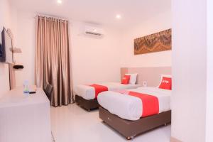 班达亚齐SUPER OYO Capital O 2018 Ring Road Guest House Syariah的酒店客房配有两张床和一张书桌