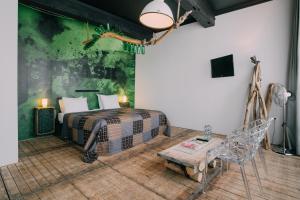 马斯特里赫特传世豪华酒店的一间卧室设有一张床和绿色的墙壁