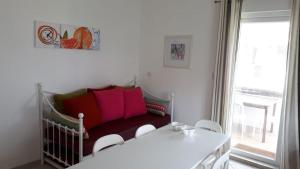 马埃堡Sacha Tourist Residence 2的客房设有一张带白色桌椅的床。