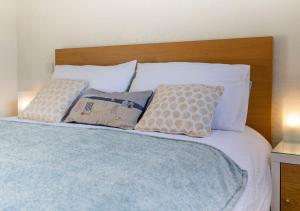 布德Stones Throw Studio Apartment Bude Cornwall的一张带白色枕头和木制床头板的床