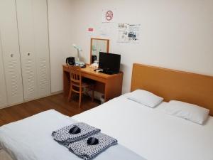 京都Ika Tsumesyo的一间卧室配有两张床和一张带电脑的书桌