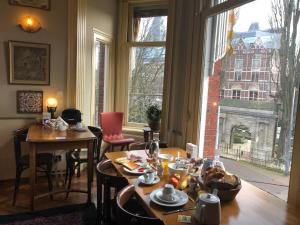 阿姆斯特丹博物馆景观酒店的客房设有桌椅和大窗户。