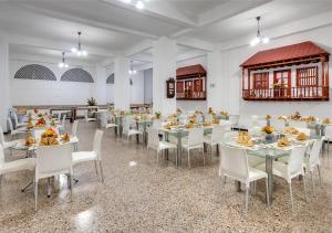 卡塔赫纳Hotel Dorado Plaza Centro Histórico的用餐室配有桌子和白色椅子
