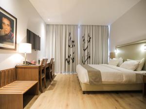 安曼拉洛坎达精品酒店的酒店客房配有一张床铺、一张桌子和一张书桌。