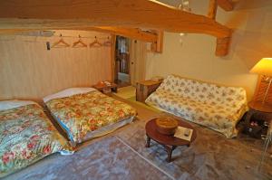 由布市由布之宿日式旅馆的客房设有两张床、一张桌子和一张沙发。
