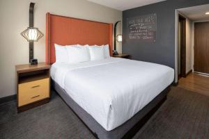 洛杉矶LAX拉金塔旅馆及套房酒店的一张大床,位于酒店房间,墙上挂着黑板