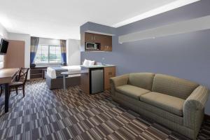 林夕昆高地温德姆BWI机场麦克罗特尔酒店套房的酒店客房设有沙发、桌子和厨房。
