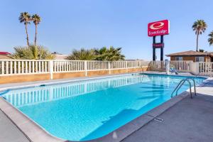 巴斯托66号历史之路伊克诺旅店的一个带酒店标志和棕榈树的游泳池