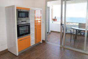 拉克鲁斯LE TERRAZZE 6的厨房配有橙色橱柜和美景桌子。