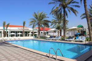 乌姆盖万Royal Residence Hotel Apartments的棕榈树度假村的游泳池
