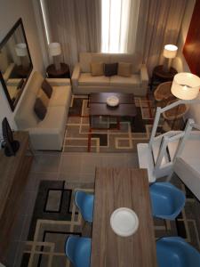 马德里阿尔卡拉套房生态酒店的客厅配有桌子和沙发