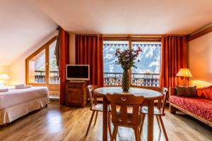 夏蒙尼-勃朗峰巴拉贡撒沃酒店的酒店客房设有床、桌子和窗户。