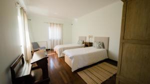 波亚里什新镇Quinta dos Lameiros的一间白色卧室,配有两张床和窗户