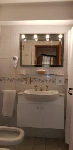 马德普拉塔卓越公寓酒店的一间带水槽、卫生间和镜子的浴室