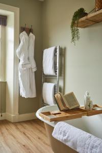 科舍姆梅休因阿姆斯宾馆的带浴缸和毛巾架的浴室