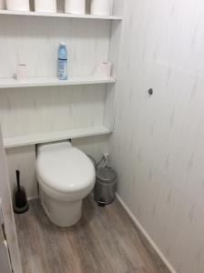 Fère-ChampenoiseChez madame loic的白色的浴室设有卫生间和架子。