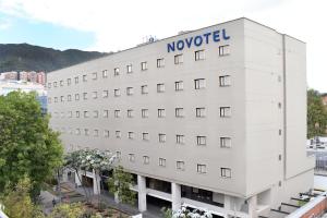 波哥大Novotel Bogota Parque 93的白色的建筑,上面有诺富特标志